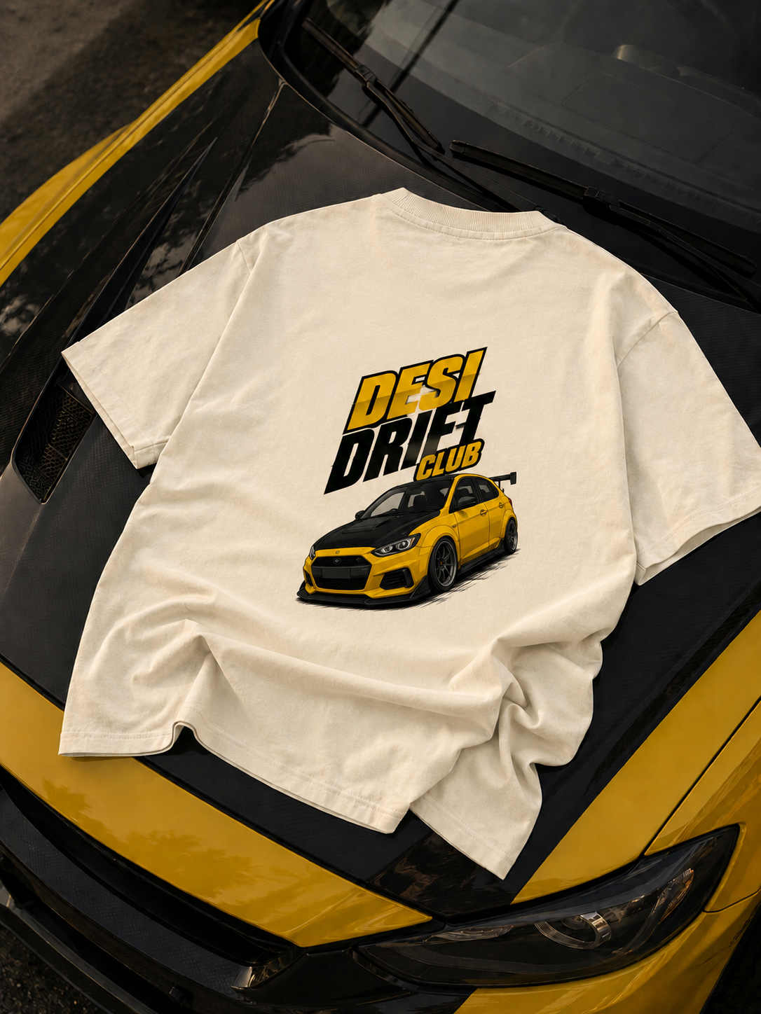graphic printed off white oversized tshirt on car hood with graphic showing yello and black sports car saying desi drift club