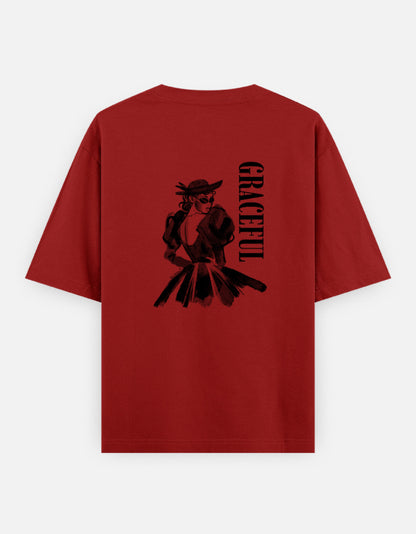 Red oversized unisex t shirt featuring a back print of a monochrome fashion illustration of a stylish woman wearing a hat and dress alongside vertical GRACEFUL typography. Made from premium 240 GSM 100% cotton with a relaxed oversized fit. Available in Black and Cream by Shisha.