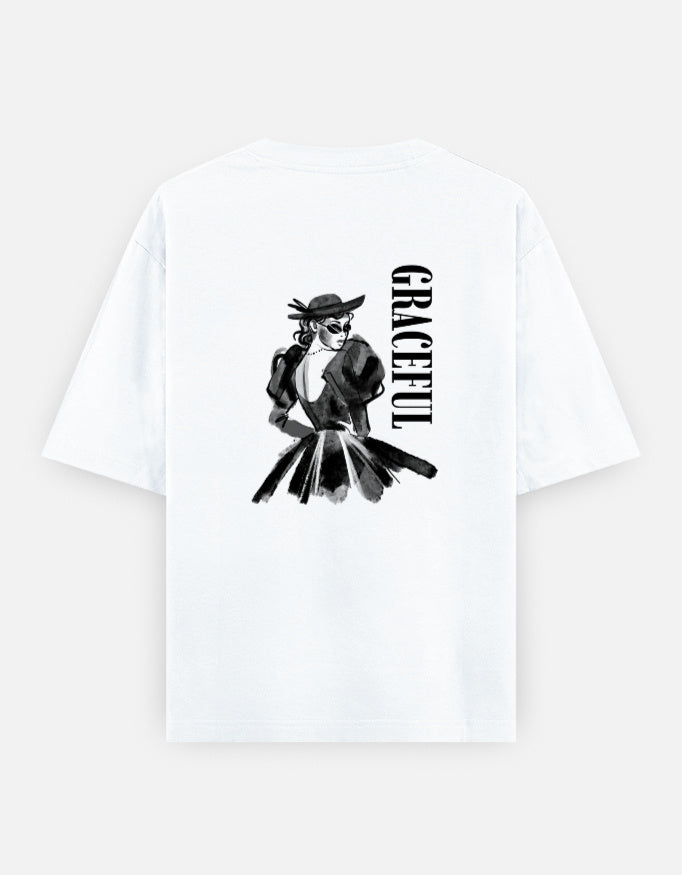 White oversized unisex t shirt featuring a back print of a monochrome fashion illustration of a stylish woman wearing a hat and dress alongside vertical GRACEFUL typography. Made from premium 240 GSM 100% cotton with a relaxed oversized fit. Available in Black and Cream by Shisha.