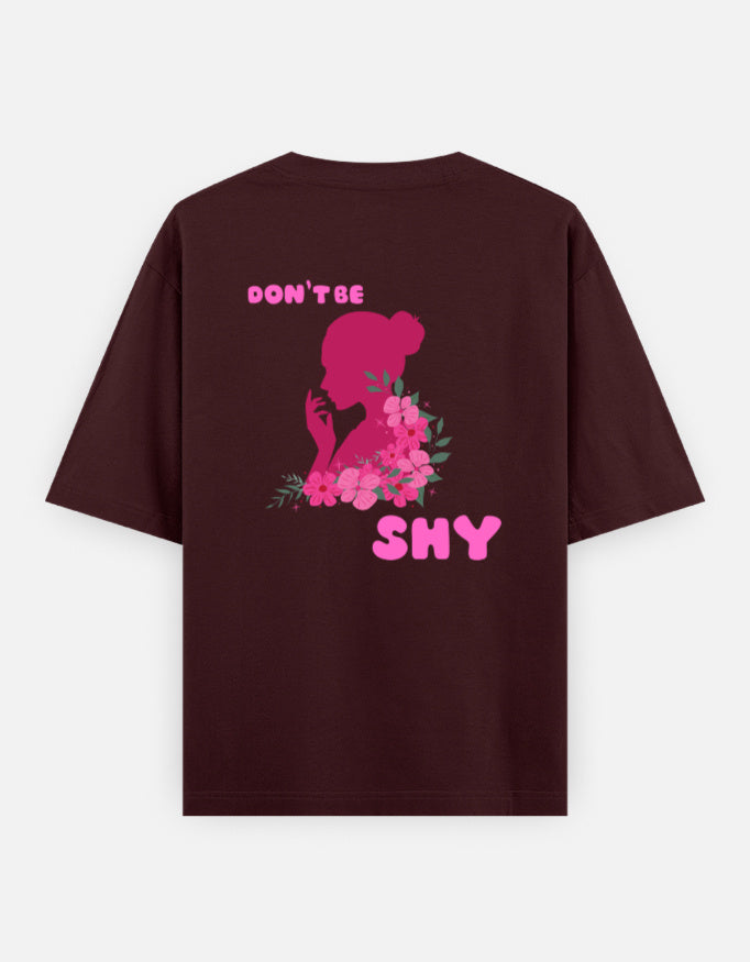oversized unisex t shirt featuring a back print of a pink floral silhouette of a woman surrounded by blooming flowers with the words DON'T BE SHY.