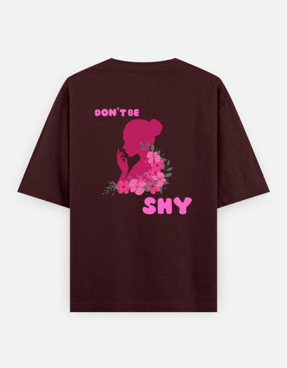 oversized unisex t shirt featuring a back print of a pink floral silhouette of a woman surrounded by blooming flowers with the words DON'T BE SHY.
