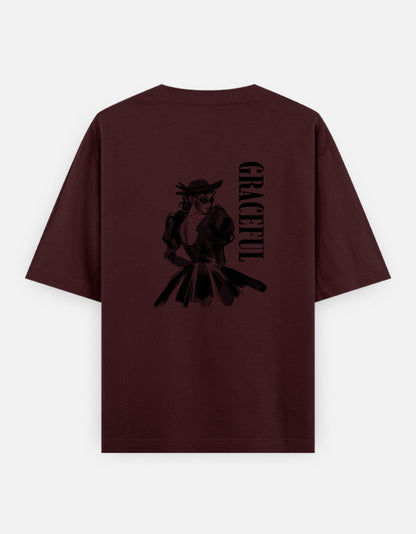 Maroon oversized unisex t shirt featuring a back print of a monochrome fashion illustration of a stylish woman wearing a hat and dress alongside vertical GRACEFUL typography. Made from premium 240 GSM 100% cotton with a relaxed oversized fit. Available in Black and Cream by Shisha.