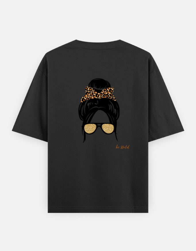Black oversized unisex t shirt featuring a back print of a minimalist fashion illustration with a high messy bun tied with a leopard print scrunchie and oversized gold sunglasses. Made from premium 240 GSM cotton with a relaxed streetwear fit. Available in Black and Cream by Shisha.