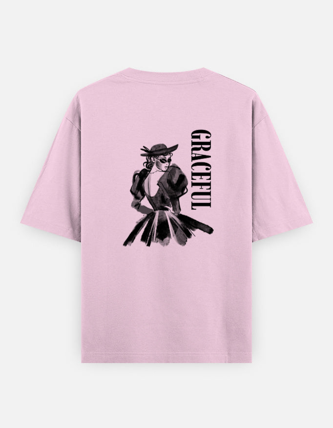 Pink oversized unisex t shirt featuring a back print of a monochrome fashion illustration of a stylish woman wearing a hat and dress alongside vertical GRACEFUL typography. Made from premium 240 GSM 100% cotton with a relaxed oversized fit. Available in Black and Cream by Shisha.