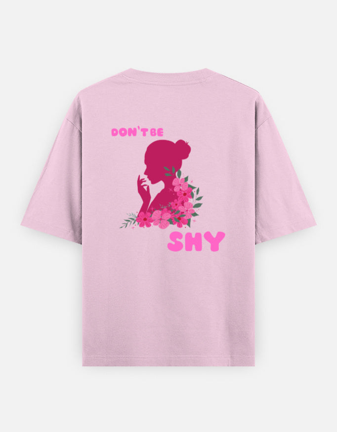 oversized unisex t shirt featuring a back print of a pink floral silhouette of a woman surrounded by blooming flowers with the words DON'T BE SHY.