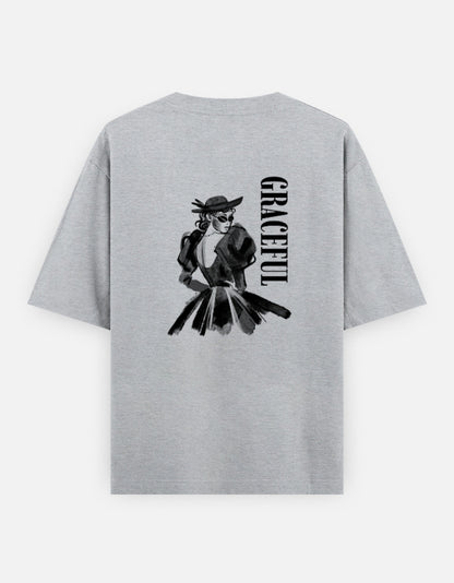 Grey oversized unisex t shirt featuring a back print of a monochrome fashion illustration of a stylish woman wearing a hat and dress alongside vertical GRACEFUL typography. Made from premium 240 GSM 100% cotton with a relaxed oversized fit. Available in Black and Cream by Shisha. 