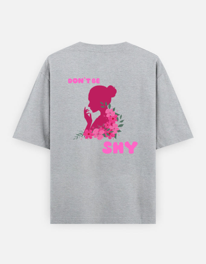 oversized unisex t shirt featuring a back print of a pink floral silhouette of a woman surrounded by blooming flowers with the words DON'T BE SHY.