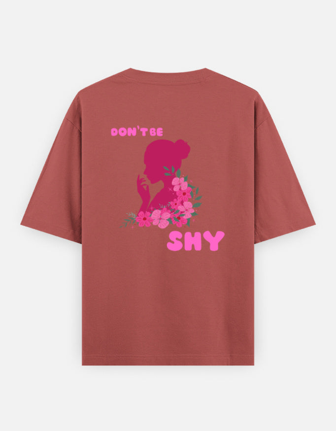 oversized unisex t shirt featuring a back print of a pink floral silhouette of a woman surrounded by blooming flowers with the words DON'T BE SHY.