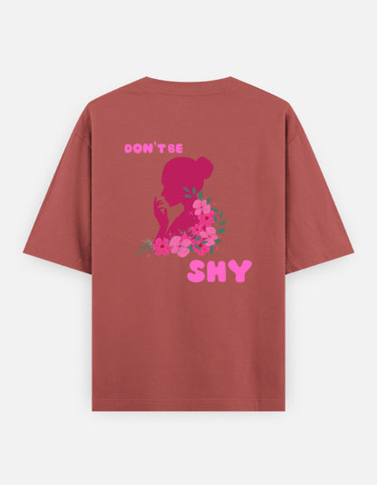 oversized unisex t shirt featuring a back print of a pink floral silhouette of a woman surrounded by blooming flowers with the words DON'T BE SHY.