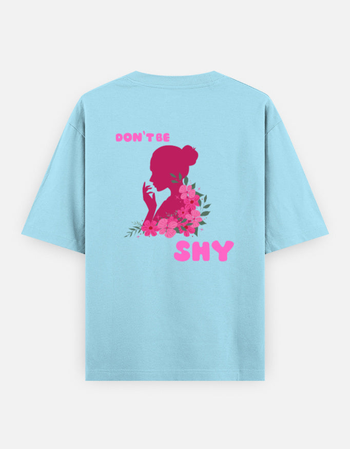 oversized unisex t shirt featuring a back print of a pink floral silhouette of a woman surrounded by blooming flowers with the words DON'T BE SHY.