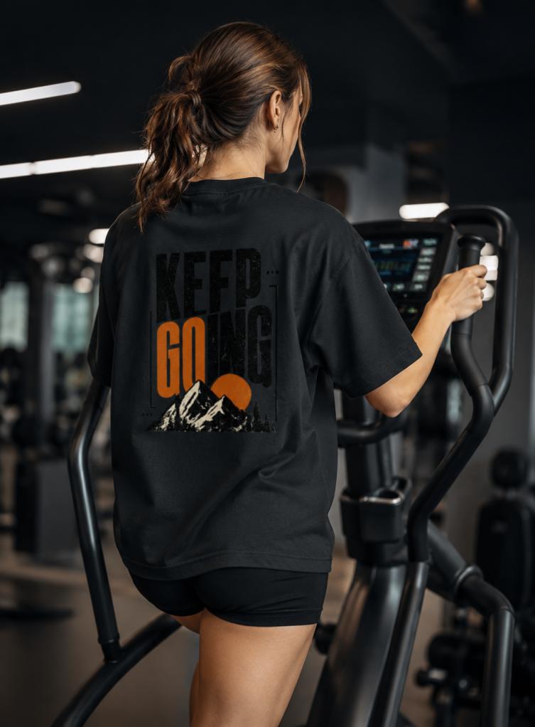 Person exercising on a machine with 'Keep Going' motivational message on a black shirt.